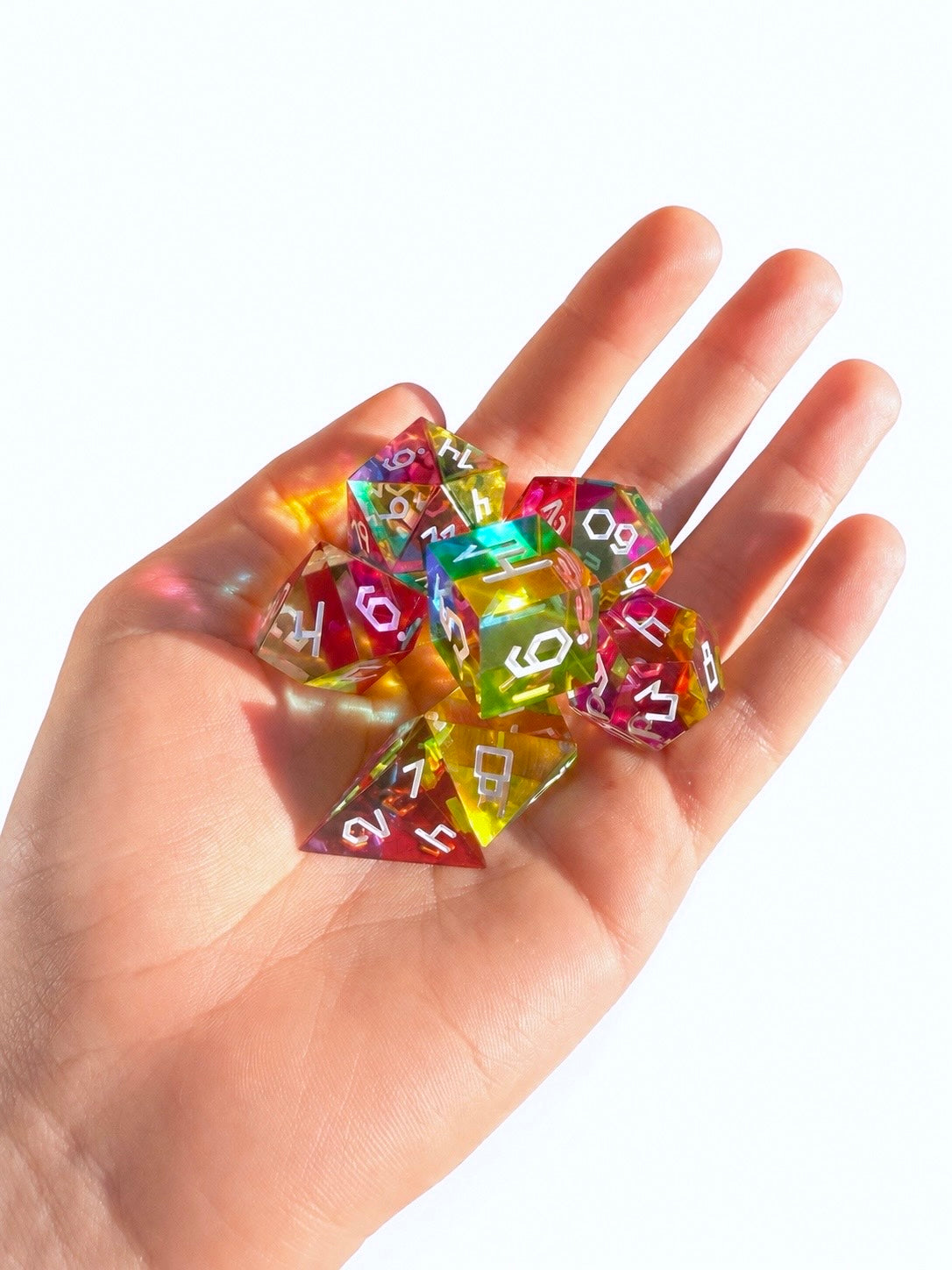 Seven translucent cyan, magenta, and yellow colour mixing dice cupped in an open palm