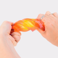 Hands twisting an orange and yellow translucent PolySquish squishy toy