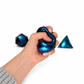 A hand squeezing a teal PolySquish Discovery Series #2 shape, with two more shapes beside it